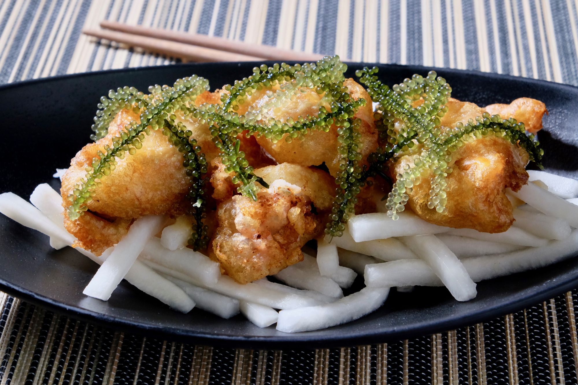 https://www.delectabilia.com/wp-content/uploads/tempura-mussels-and-octopus-on-pickled-daikon.-soy-mustard-drizzle.-sea-grapes.jpg